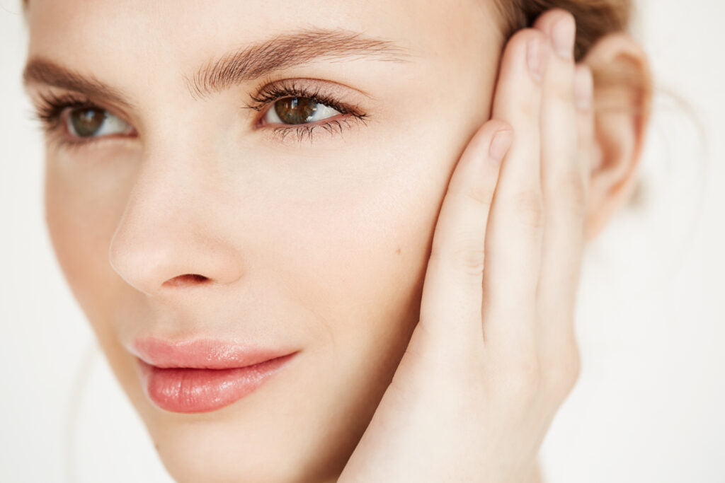 Close up of young beautiful girl smiling touching face spa beauty health and cosmetology concept